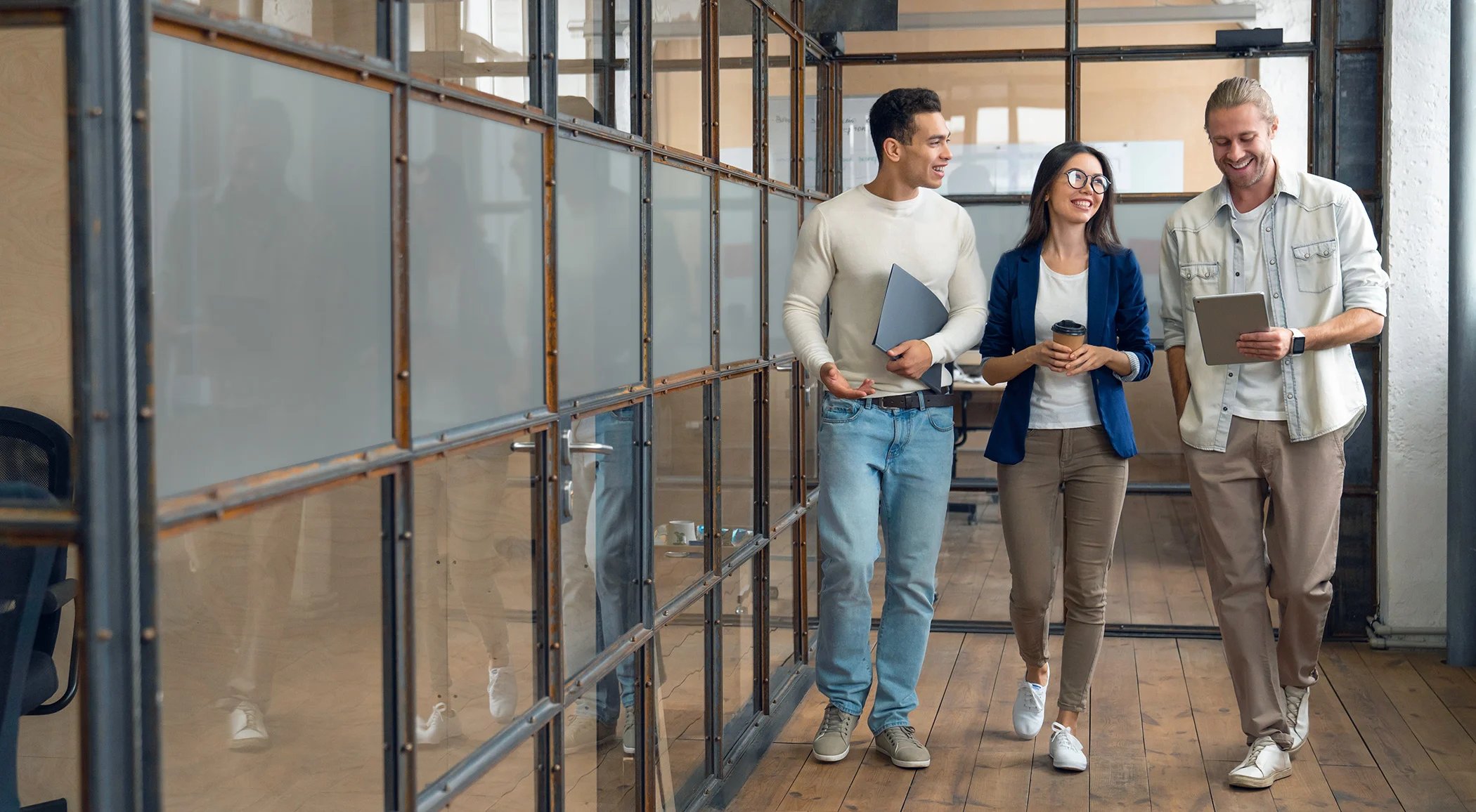 Collegues-talking-while-walking-down-hall-HERO