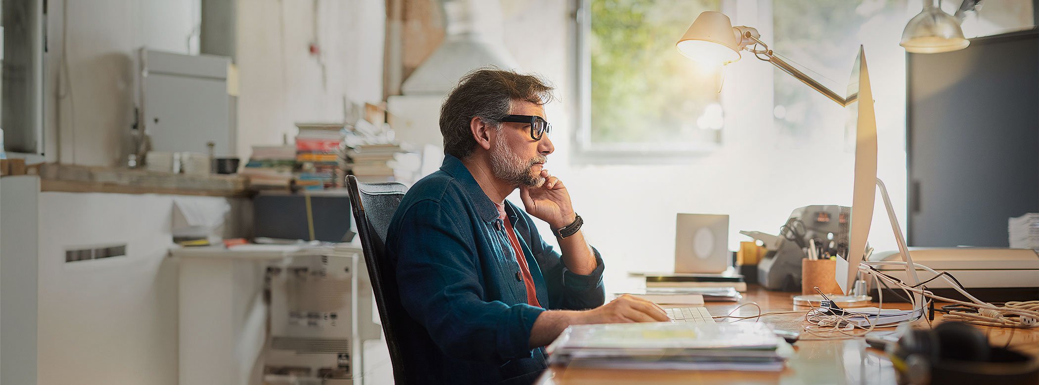 Elderly-man-with-glasses-smiling-and-using-PC-HERO-Vignet